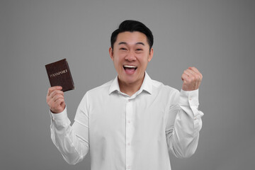 Immigration. Excited man with passport on grey background