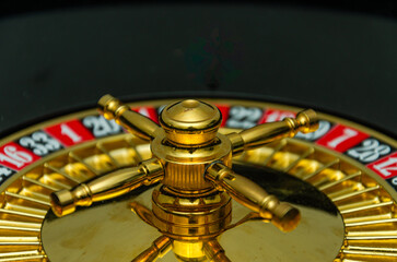 Casino roulette wheel with ball and numbers on a dark background, close-up