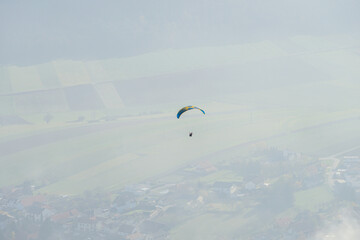 Two paragliders in the air on a cludy day at Hohe Wand in Lower Austria