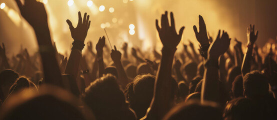 The electric energy of a rock concert captured as fans raise their hands in unison under the golden...