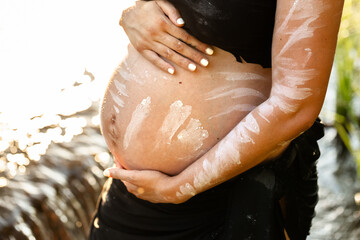 Aboriginal Australian pregnant woman with traditional ochre paint on belly
