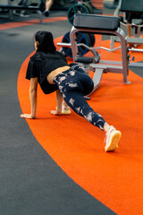 a young girl in sportswear in the gym does stretching exercises before the start of training