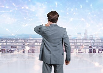 Businessman with office buildings in city at night.