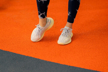 Fototapeta premium close-up of a girl in sportswear in the gym doing leg exercises before starting a workout