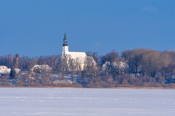 Church in the snow. Wintry Lutheran Church Emerges Above the Trees. 