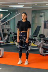 Fototapeta na wymiar young girl in sportswear in the gym doing exercises with dumbbells training a healthy lifestyle