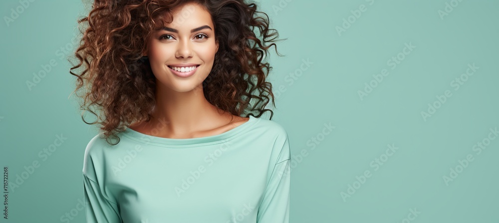 Wall mural Young happy woman in casual looks, smiling at camera, isolated on pastel background with copy space