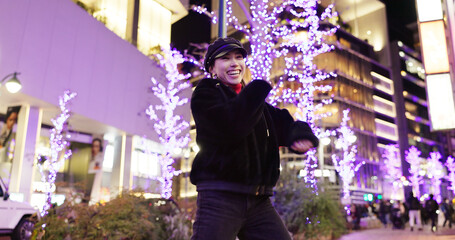 Woman in Japan, dancing in city at night with energy and fun, happiness and freedom outdoor. Celebration, party and music with Japanese dancer on urban street, light and positivity for nightlife