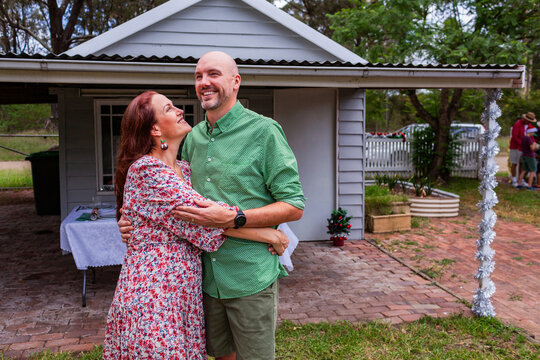 Portrait of Aussie couple in their forties in front of country garage at christmas