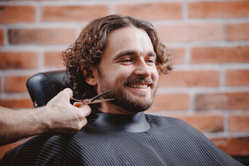 Portrait happy smile Man in barber chair hairdresser styling his hair. Barbershop banner background