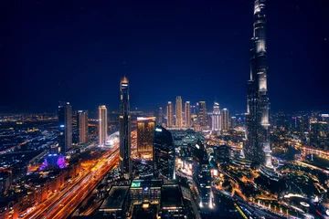Fotobehang Aerial top view Dubai, night amazing skyline cityscape with illuminated skyscrapers, neon color. Modern downtown United Arab Emirates, sky with stars © Parilov