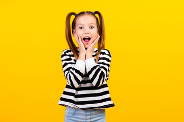 Photo of cheerful impressed small kid wear striped sweater open mouth arms cheeks isolated yellow color background