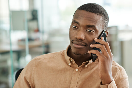 Young African businessman talking on his cellphone at work
