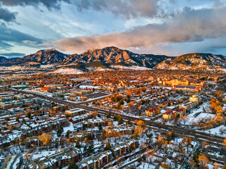 Drone view of University of Colorado, Boulder and the Flatirons at sunrise in the winter snow. - obrazy, fototapety, plakaty