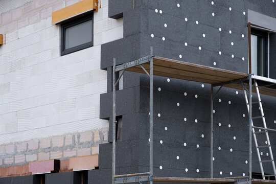 modern thermal insulation materials. building New House in process insulation of the wall of the house with layers Exterior covering in construction site.