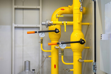 Pipes of gas boiler station. Yellow pipeline with valves. Boiler room purge pipelines. Gas pipes with manometers. Engineering premises of enterprise. Boiler station running on methane. Gas supply