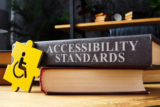 Accessibility standards book and disabled person sign.