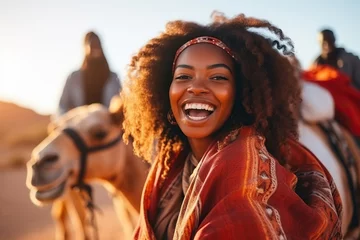 Rolgordijnen Happy female African American tourist having fun enjoying group camel ride tour in the desert © wolfhound911
