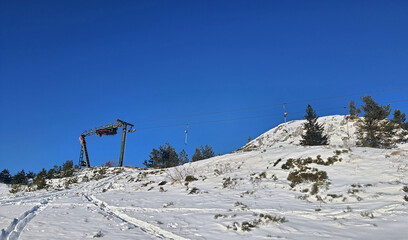 Naklejka na ściany i meble Old T-bar ski lift in the mountains on a sunny day