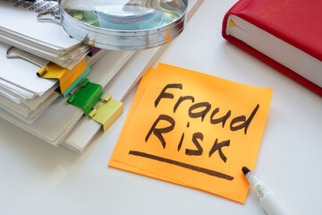Fraud risk inscription and stack of papers.