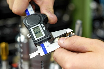 The worker measures the cutters with a caliper to work on milling and turning machines.