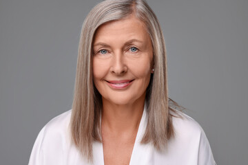 Portrait of beautiful senior woman on grey background