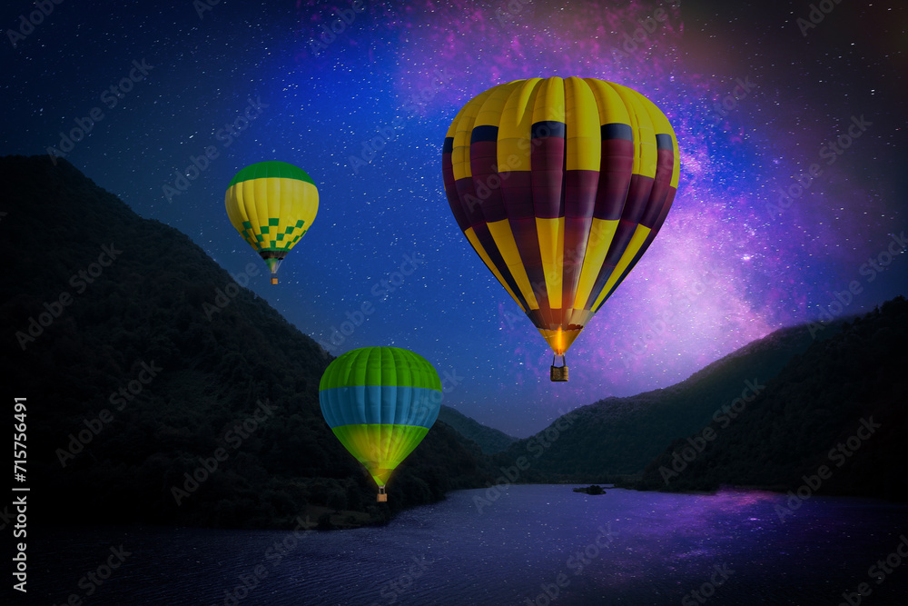 Sticker Bright hot air balloons flying over lake at night