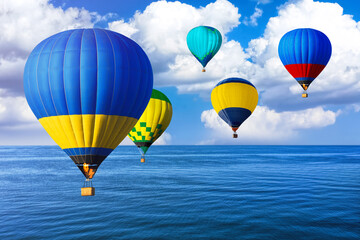 Bright hot air balloons flying over blue sea