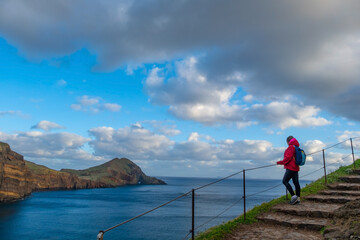 Tourists on hiking path on Ponta de Sao Lourenco Madeira Portugal. Green landscape cliffs and Atlantic Ocean. Ative day, travel background