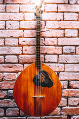 Naklejka premium Musical instrument domra on brick wall background