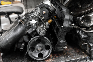 Broken car engine parts in a car repair shop, close up