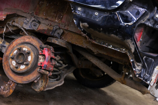 Close-up photo of brake disk and suspension of an old broken car