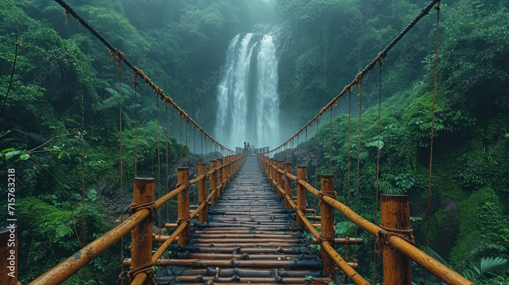 Aufkleber a long wooden bridge with a waterfall in the background in the middle of a jungle with lots of green