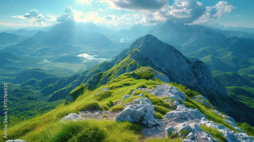 Poster a scenic view of a mountain range with green grass and mountains in the background and a bright sunb
