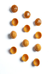 Nuts with condensed milk or caramel. Pattern on a white background. Minimalism