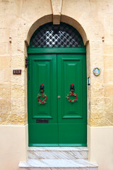 Wooden green door in downtown of Sliema, Malta