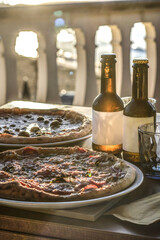 pizze e birre sul tavolino di una pizzeria