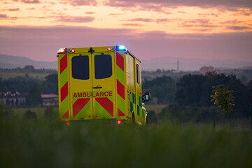 Yellow ambulance car of emergency medical service on country road. Themes rescue, urgency and...