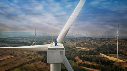 Windmill engineer wearing PPE standing on wind turbine.  engineer feel success after good work. He...