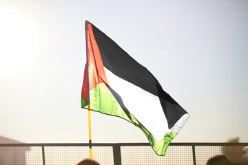 Palestinian flag flying freely in the suburban suburbs backlit at sunset