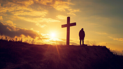 A contemplative scene featuring a lone figure at the base of a rugged wooden cross, silhouetted against the warm hues of a sunset. The emotive atmosphere captures the solemnity and - obrazy, fototapety, plakaty