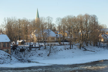  Winter city landscapes of Kuldiga, Latvia. Ancient buildings through a pattern of trees. High quality photo