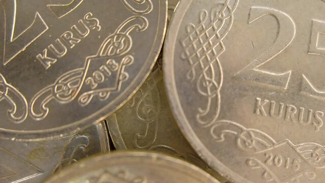 A macro shot of a 25 Kuruş coin with the camera panning from left to right, showing the fine lines and patterns of the currency. The coin is made of nickel-plated steel and has a round shape. 