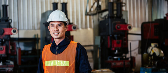 Asian man engineer industrial foreman standing at factory. technician worker in safety uniform....