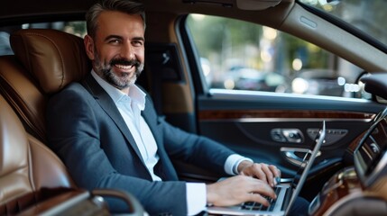 Fototapeta na wymiar Handsome businessman working on laptop computer while sitting in luxury car.