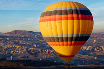 Obraz premium Hot air balloon flight in Goreme in Turkey during sunrise. Ride in a hot air balloon, the most popular activity in Cappadocia. Romantic and famous travel destination.