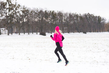 Picture of young sportswoman running in winter forest