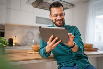 One young adult caucasian man work use digital tablet online at home