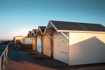 brightly painted wooden beach huts at the seaside in the UK