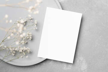 Blank wedding invitation card mockup with dry gypsophila flowers decor, copy space